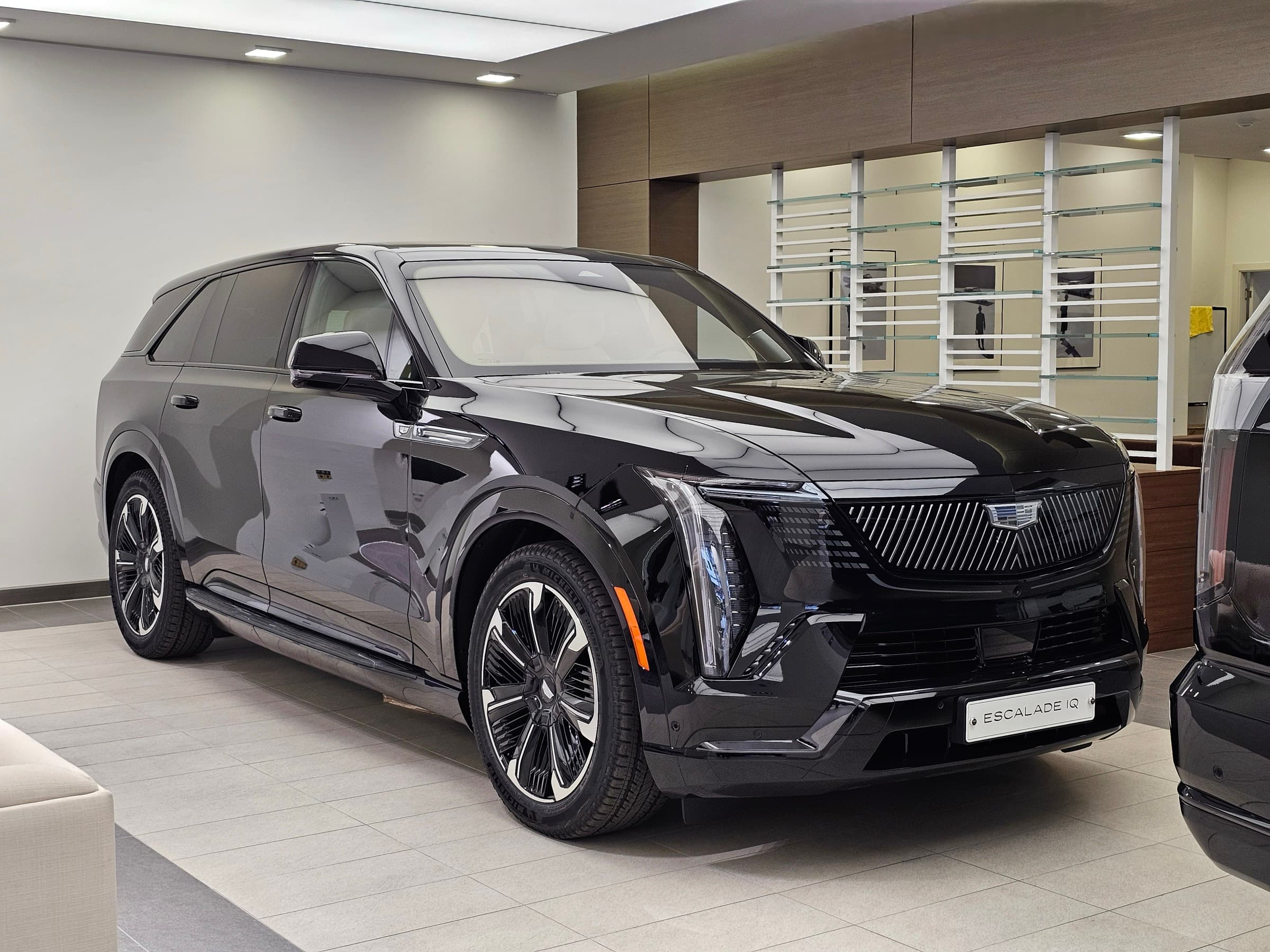 Cadillac Escalade IQ Premium Sport in Black Raven inside a dealership showroom