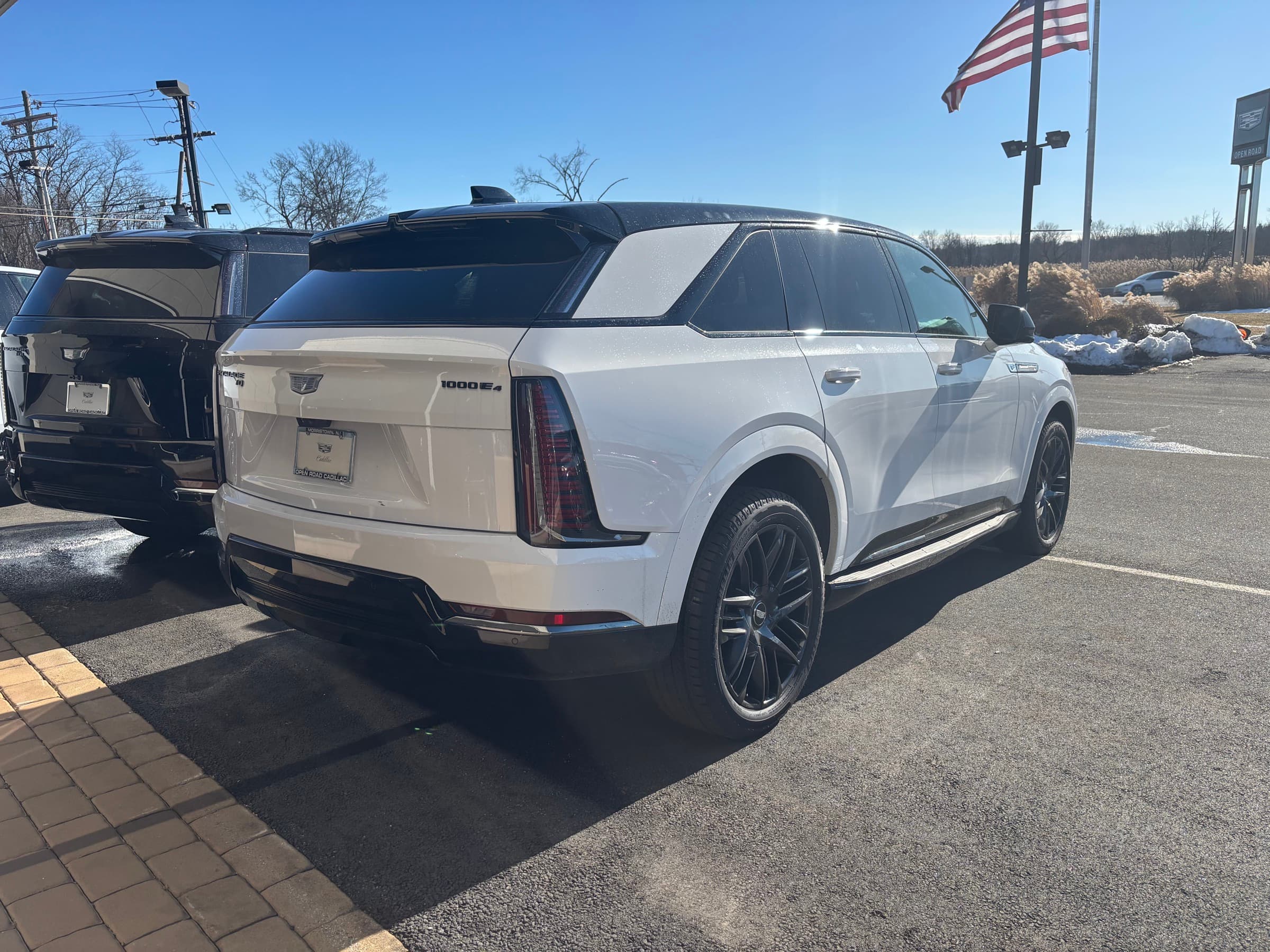 2026 Cadillac Escalade IQ rear three-quarter view showing split taillamps and 1000E4 badge