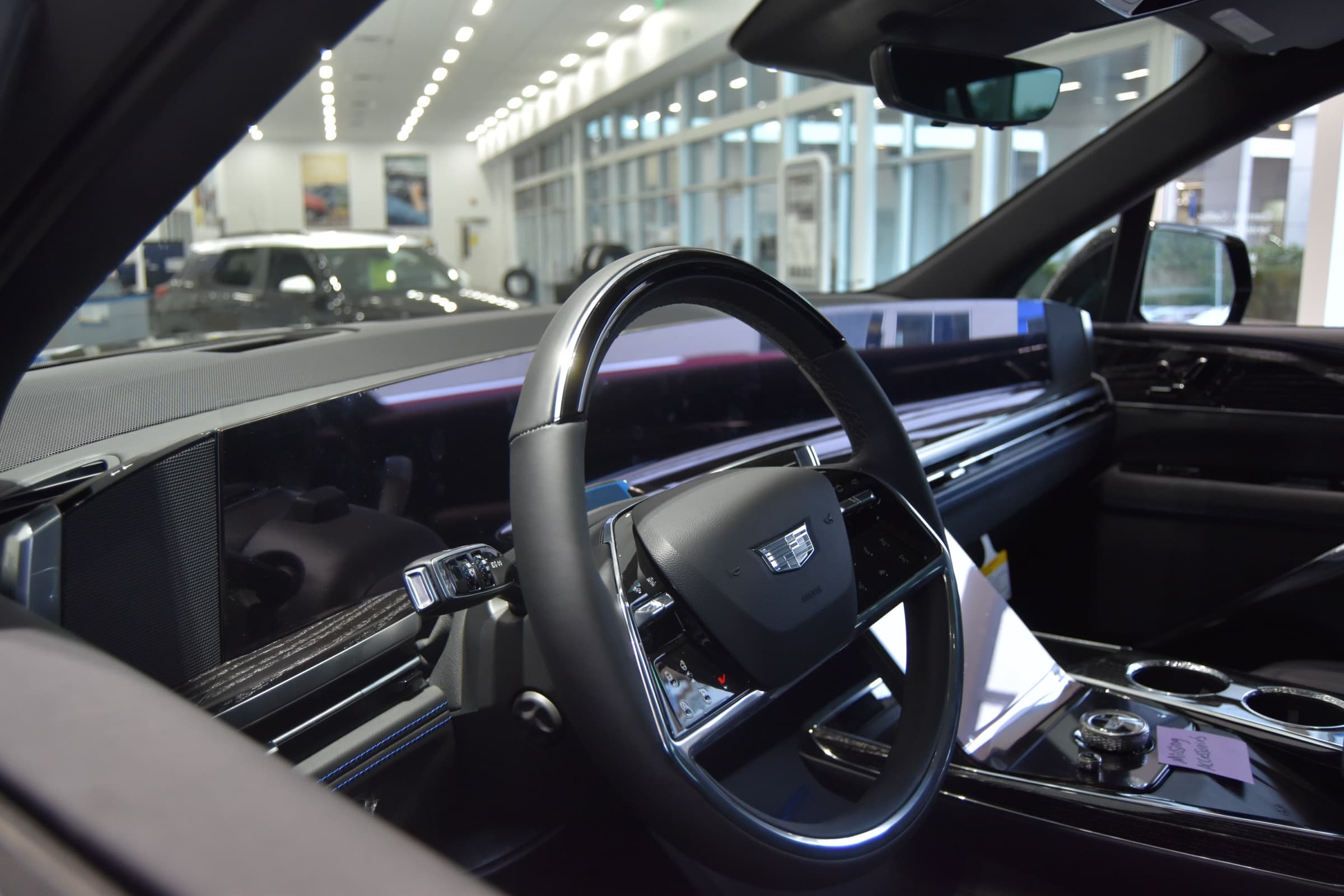 Cadillac Escalade IQ front cabin showing the curved pillar-to-pillar 55-inch display and steering wheel