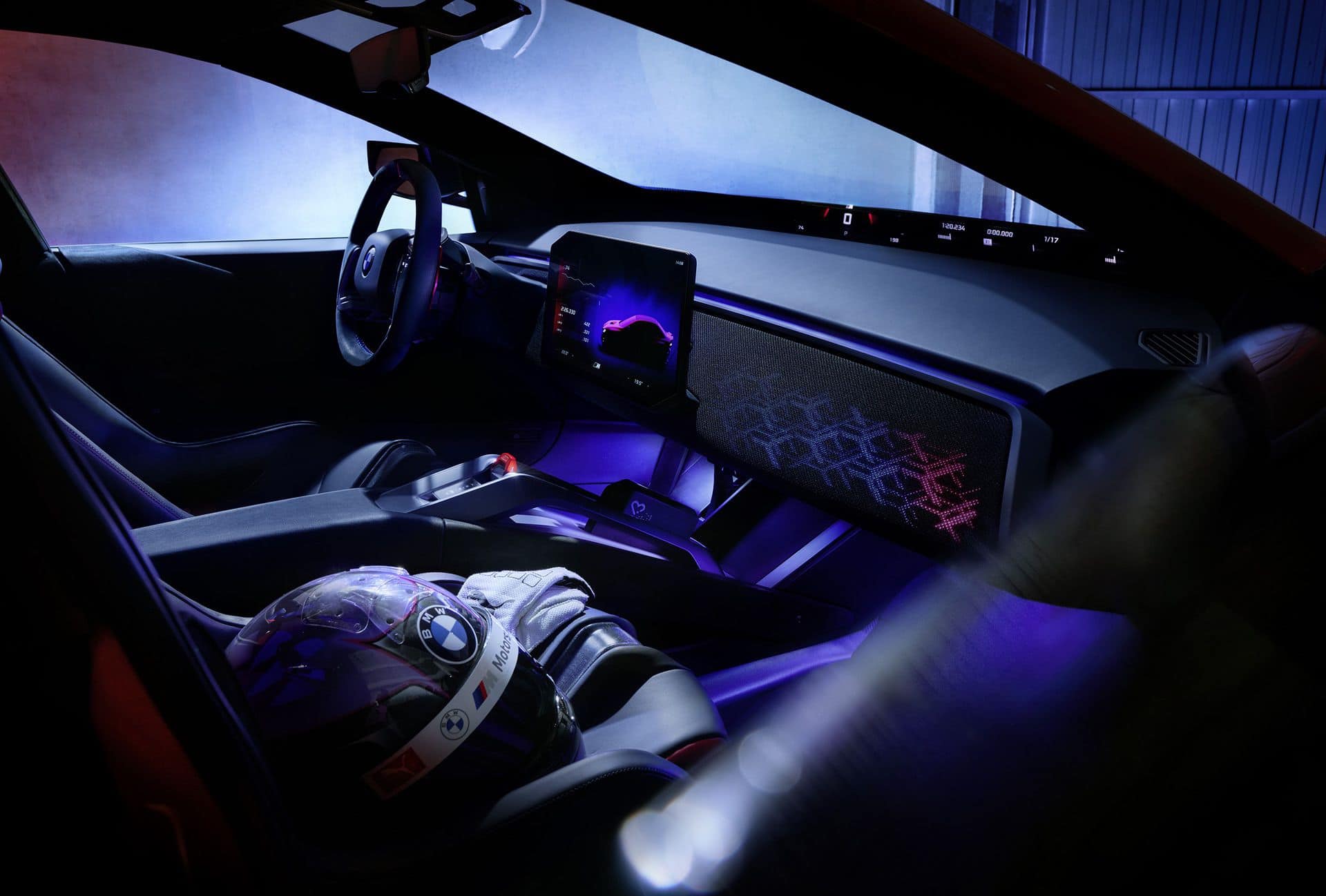BMW M Concept Neue Klasse electric M3 cockpit at night with a BMW M helmet on the seat and a panoramic display