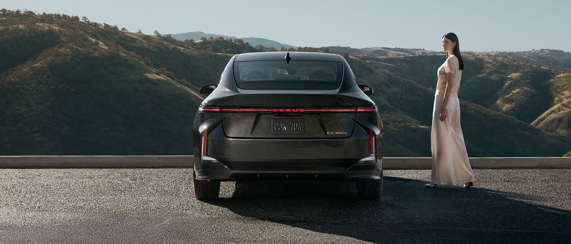 Rear three-quarter view of the 2026 Lexus ES 350e EV in Caviar exterior color