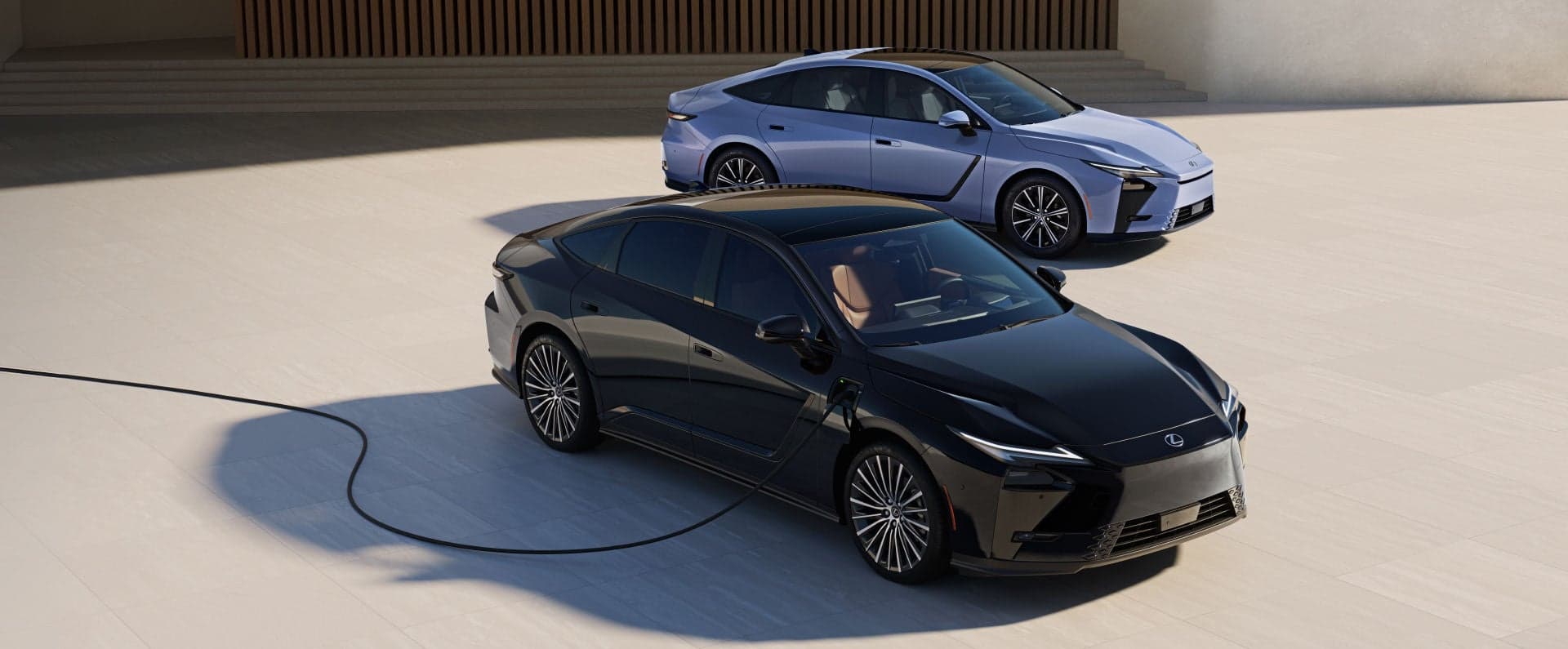 2026 Lexus ES hybrid beside an electric ES 500e connected to a home charger, front three-quarter view