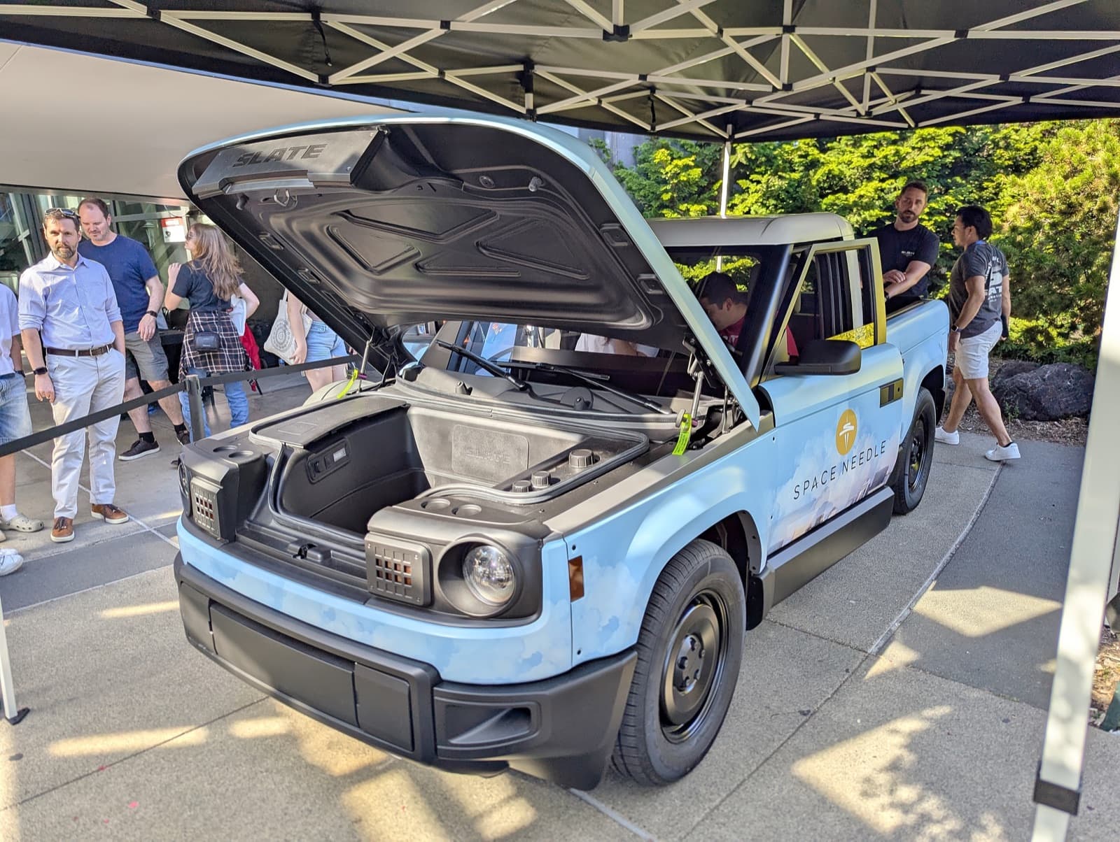 Slate electric pickup truck in gray composite body panels, front three-quarter view