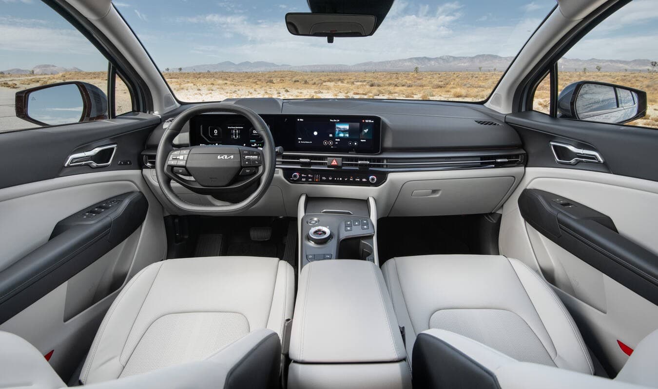 2026 Kia Sportage Hybrid interior showing the front seats, dashboard, steering wheel, and central touchscreen