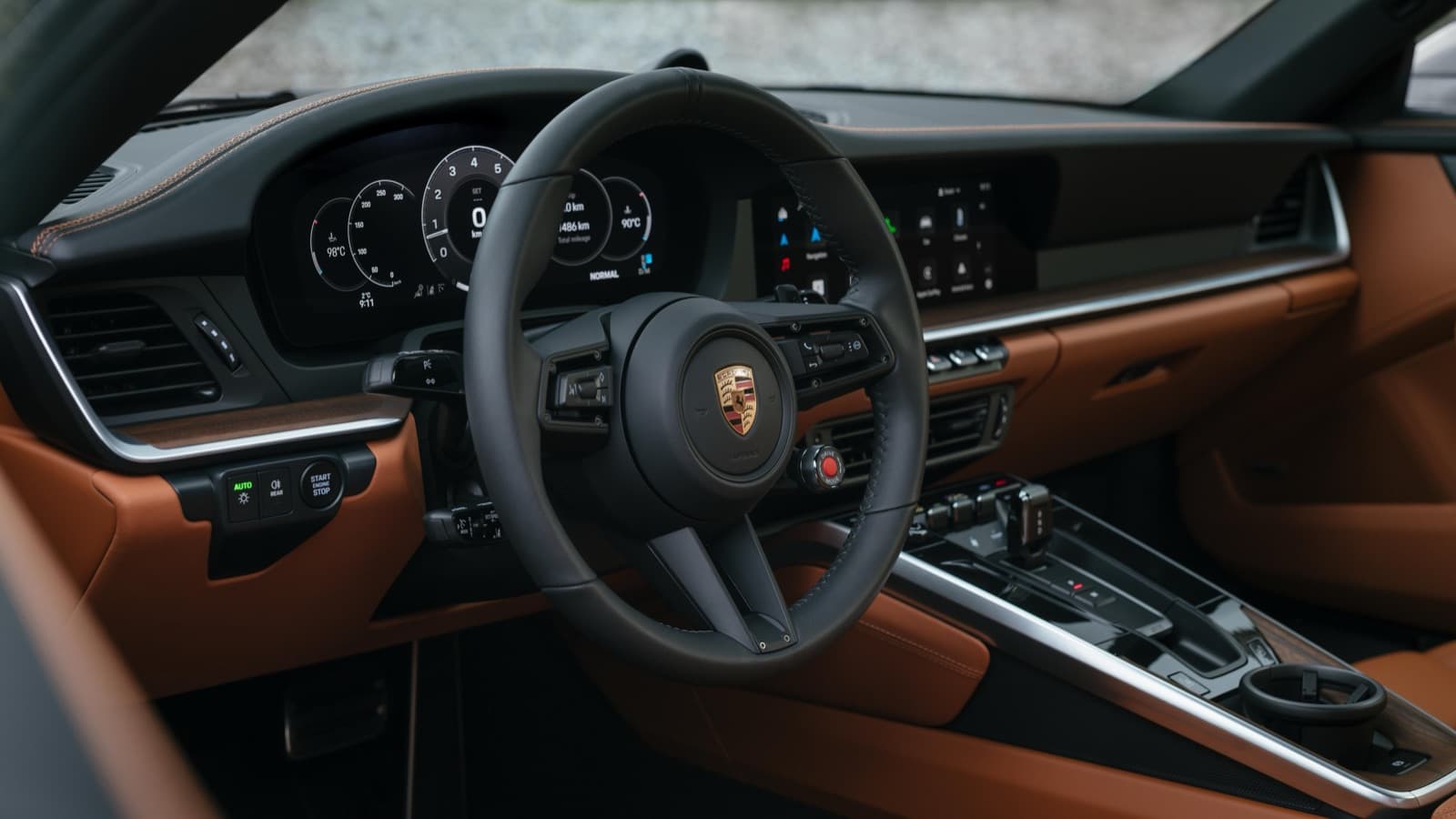2026 Porsche 911 Carrera S cockpit with 12.6-inch digital cluster and brown leather