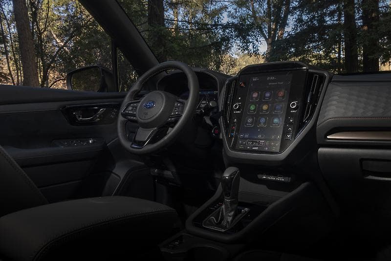 Subaru Forester dashboard showing the 11.6-inch portrait touchscreen, gear selector, and dark interior