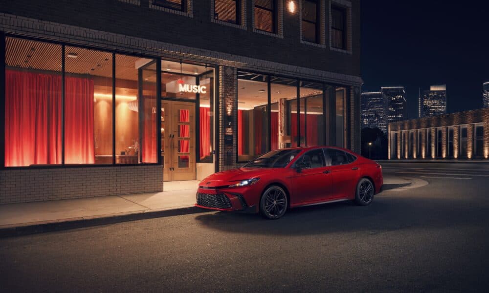 2026 Toyota Camry SE Nightshade Edition in red with satin-black wheels, parked at night
